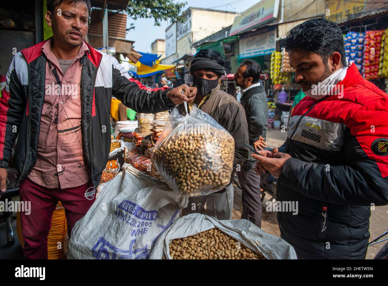 Ghaziabad, Indien. 12th Januar 2022. Ein indischer Mann sah, wie er am Vorabend des Lohri-Festivals auf dem Naya Ganj-Markt Erdnüsse kaufte.Lohri ist ein beliebtes Erntefest, das hauptsächlich im Norden Indiens und vor allem von Hindus und Sikhs aus der Punjab-Region gefeiert wird. Lohri markiert das Ende des Winters und ist ein traditionelles Willkommen von längeren Tagen und Sonnenreise auf die nördliche Hemisphäre in der Punjab Region. (Foto von Pradeep Gaur/SOPA Images/Sipa USA) Quelle: SIPA USA/Alamy Live News Stockfoto