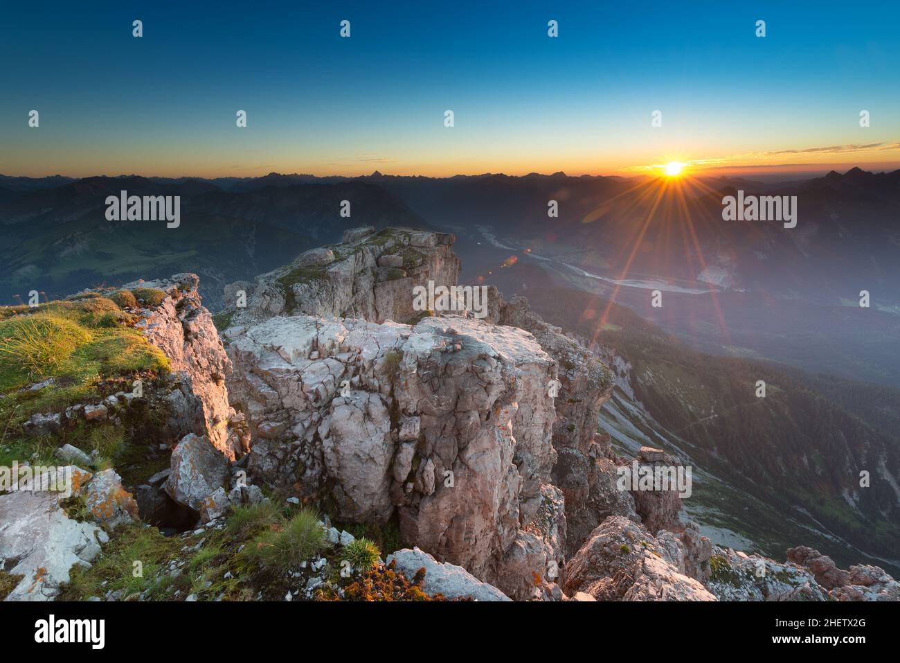 Beleuchtete Felsen auf dem Gipfel des Berges bei stimmungsvollen Sonnenaufgängen Stockfoto
