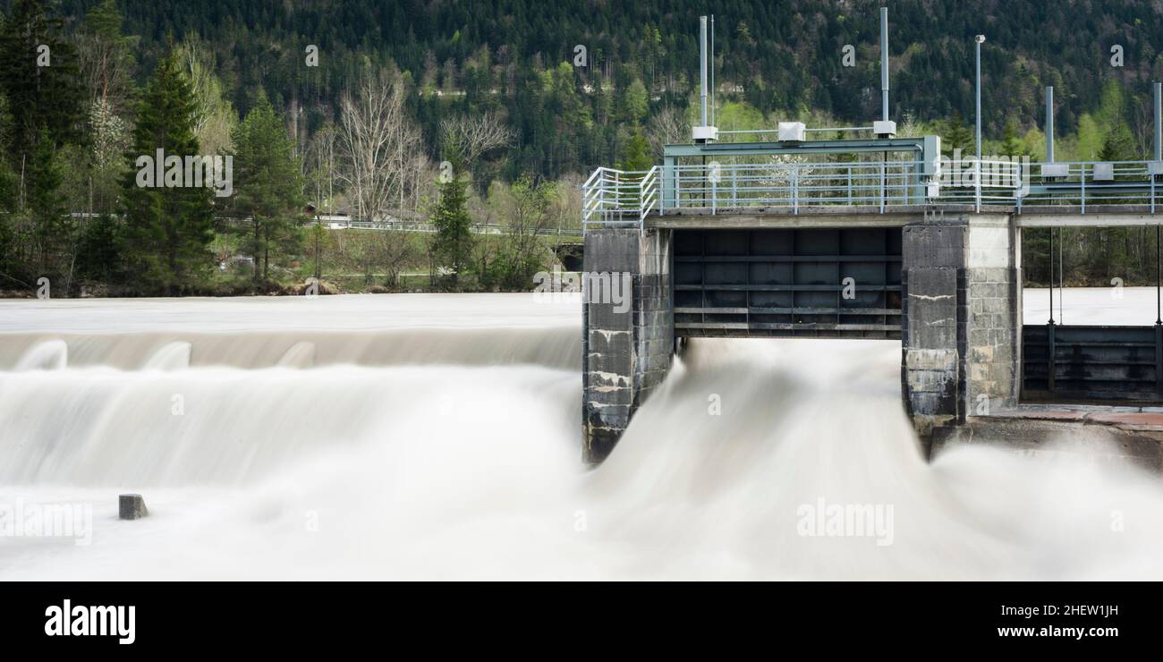 Alte Wehrpflanze mit fließendem Wasser und Bäumen im Hintergrund mit watergate Stockfoto