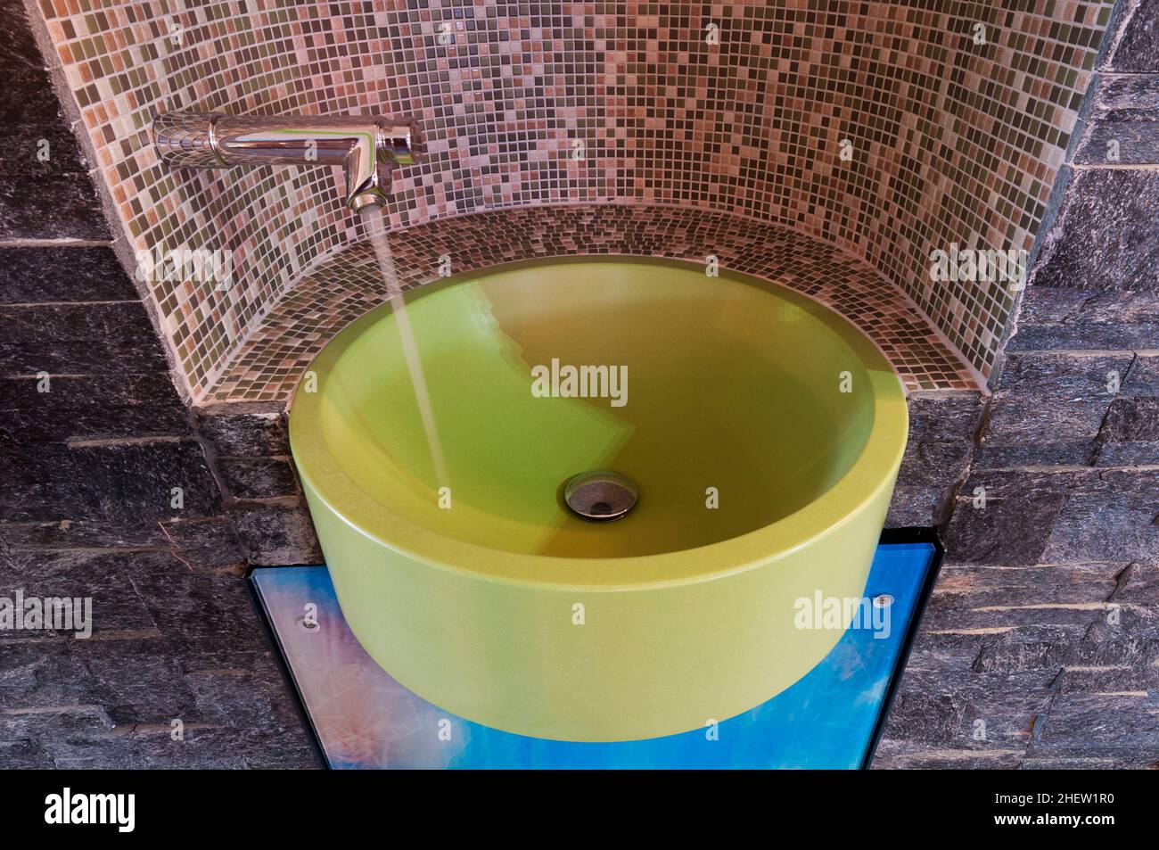 Grüne Waschschüssel mit Wasserhahn, vernickelt mit Mosaikfliesen und fließendem Wasser Stockfoto