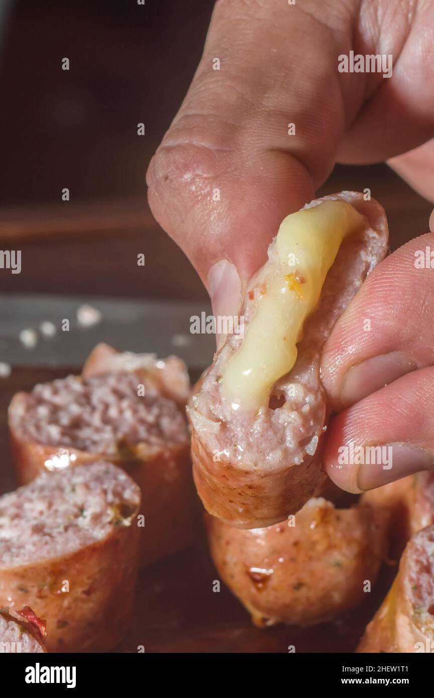 Wurst in Scheiben geschnitten ​​on ein Holzbrett mit Käsestücken im Inneren der Wurst, selektive Fokus und Kopierer Platz Stockfoto