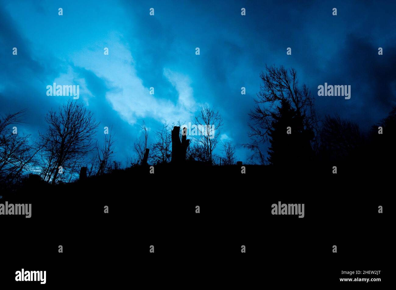 Mystische Landschaft mit bewölktem Himmel, während die blaue Stunde Stockfoto