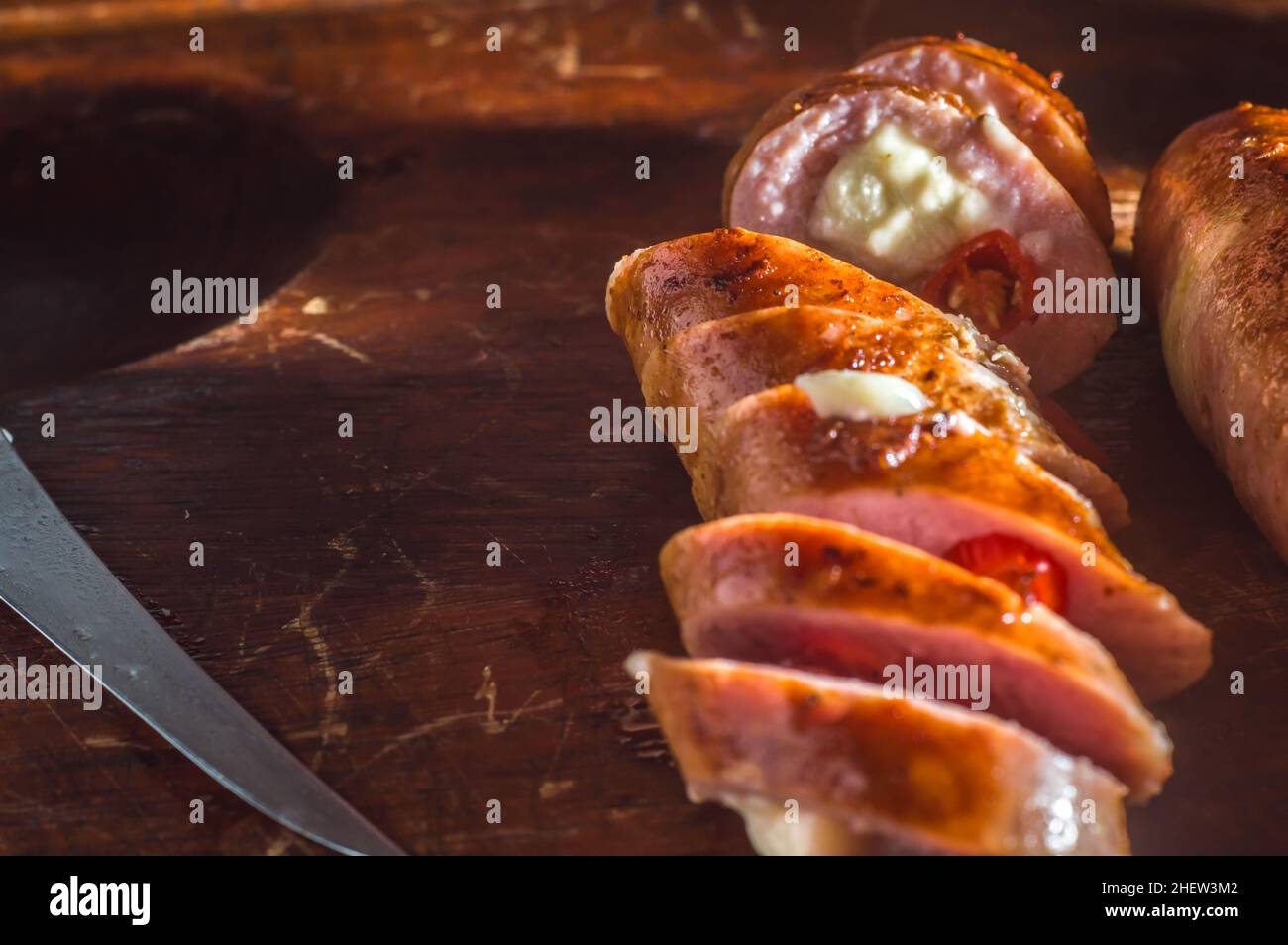 Wurst und Paprika, handwerkliche Wurst mit Käse und Pfeffer auf einem Holzbrett, Kopierraum und selektiver Fokus Stockfoto