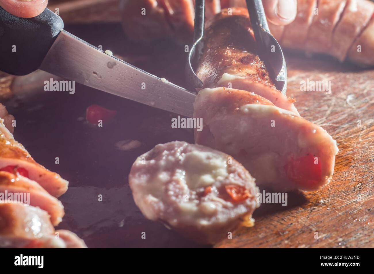 Wurst und Paprika, handwerkliche Wurst mit Käse und Pfeffer auf einem Holzbrett, Kopierraum und selektiver Fokus Stockfoto