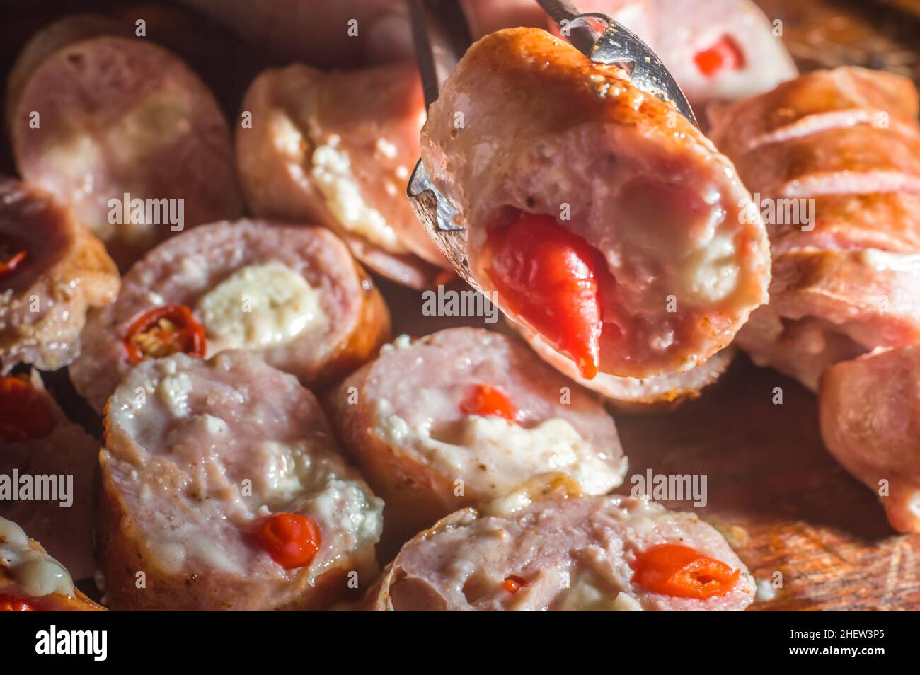 Wurst und Paprika, handwerkliche Wurst mit Käse und Pfeffer auf einem Holzbrett, Kopierraum und selektiver Fokus Stockfoto