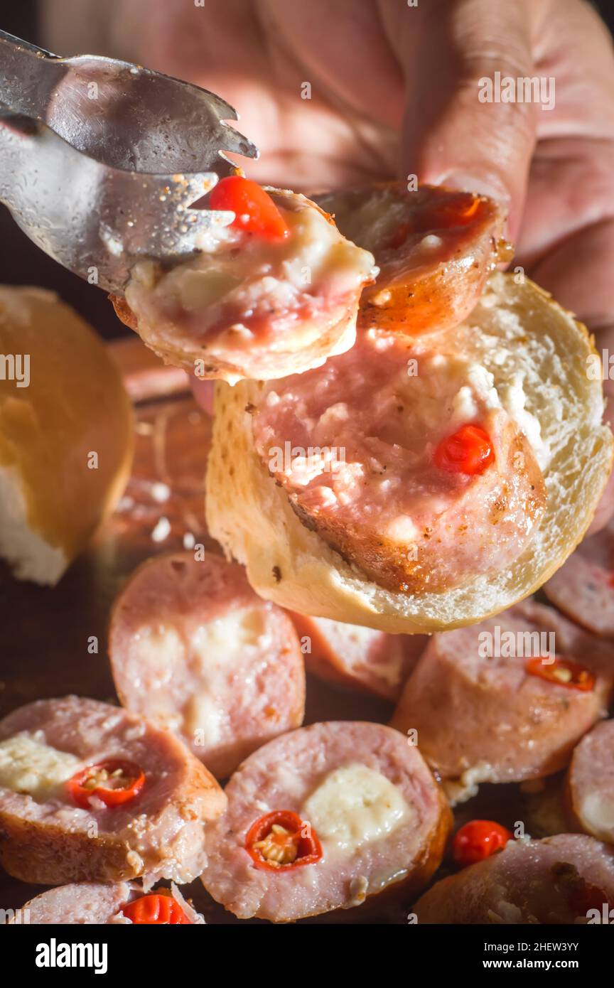 Wurst und Paprika, handwerkliche Wurst mit Käse und Pfeffer auf einem Holzbrett, Kopierraum und selektiver Fokus Stockfoto