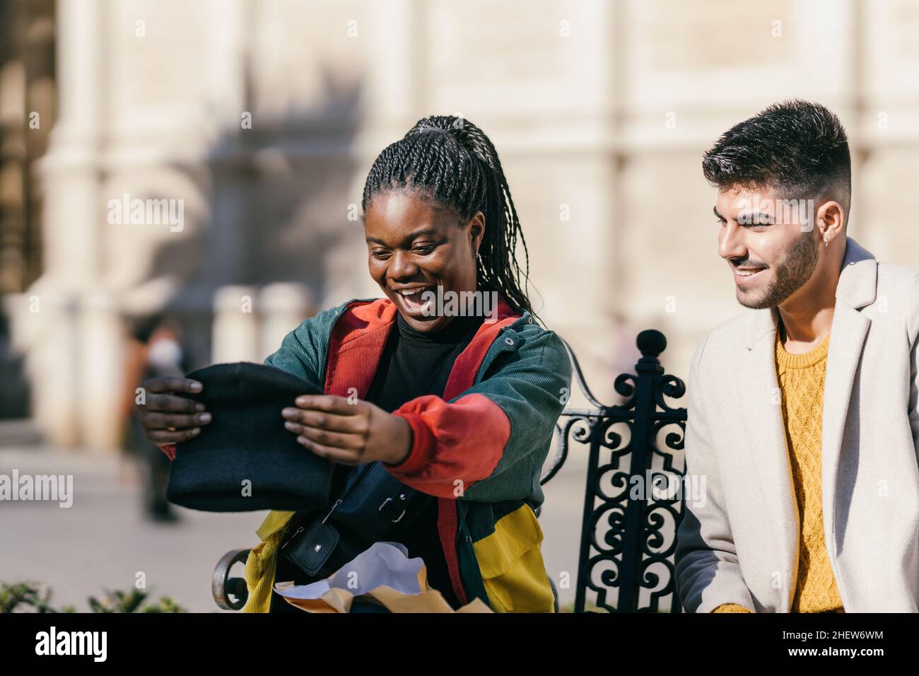 Eine überraschte afrikanerin mit einem Hut, den sie gerade als Geschenk erhalten hat Stockfoto