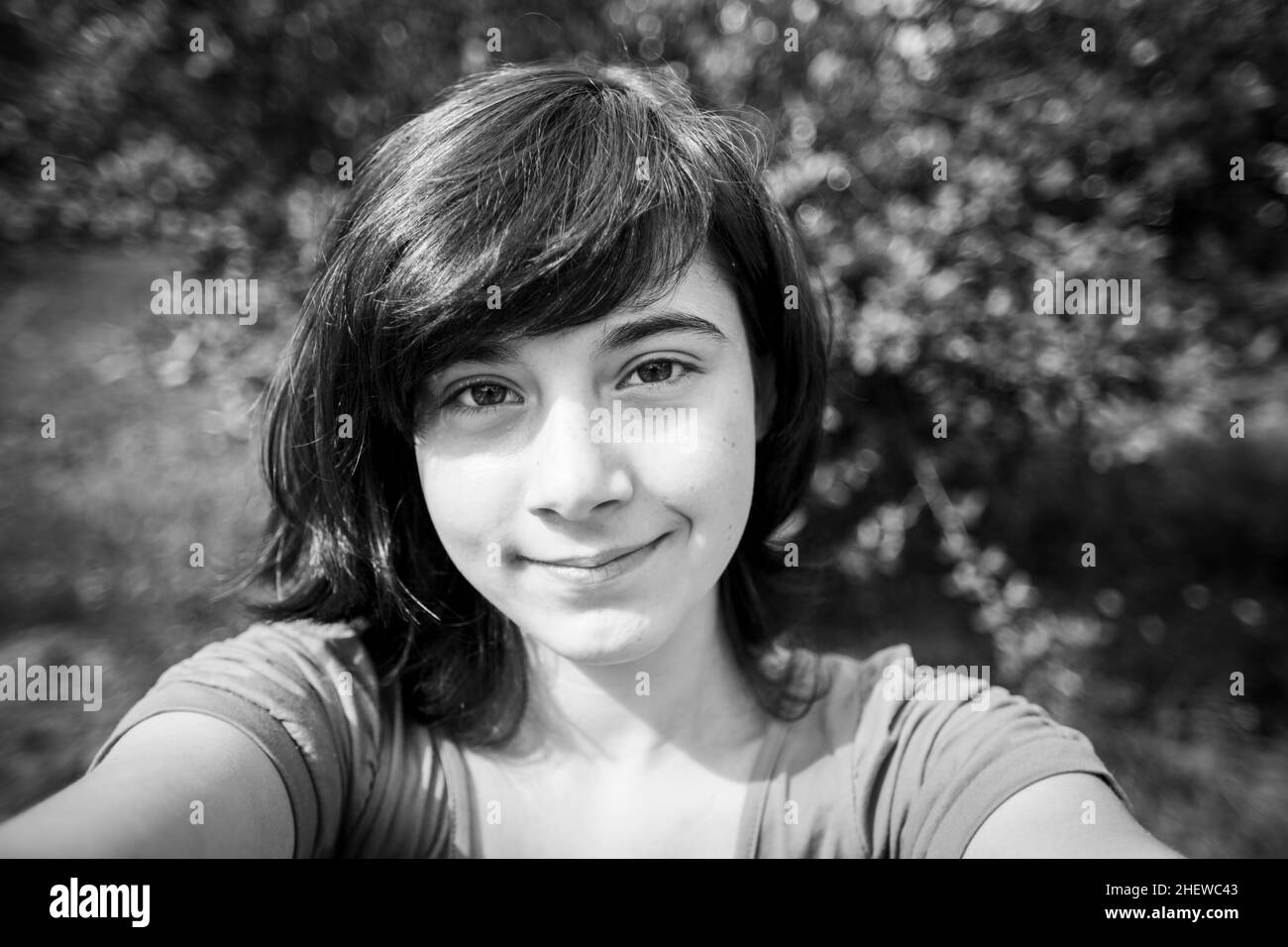 Ein Mädchen macht ein Selfie im Park. Schwarzweiß-Foto. Stockfoto
