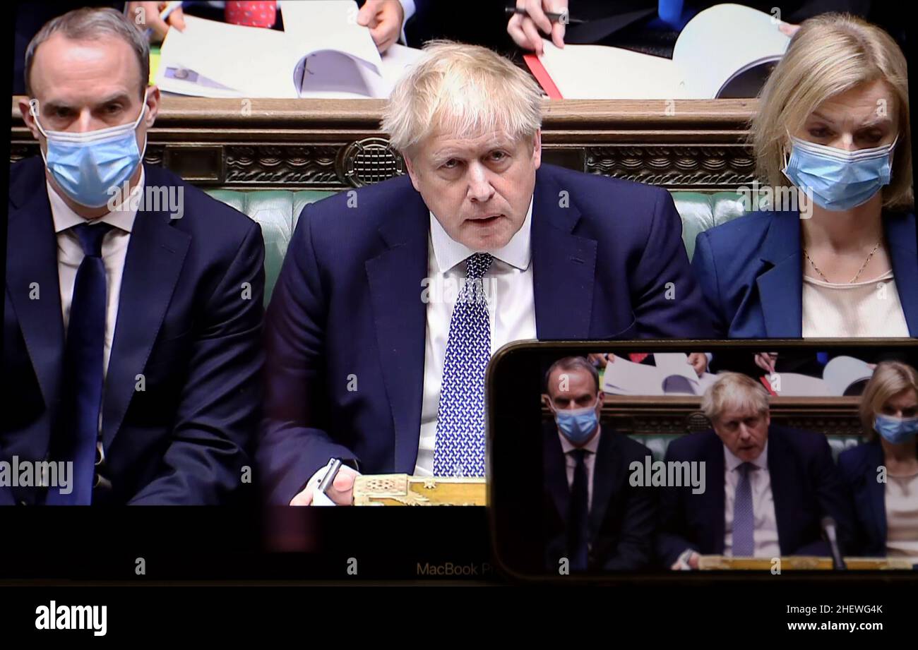 LONDON, 13. Januar 2022 (Xinhua) -- der britische Premierminister Boris Johnson (C) wird auf einem Bildschirm angezeigt, während er am 12. Januar 2022 an der wöchentlichen Fragestunde des Premierministers in London, Großbritannien, teilnimmt. Boris Johnson entschuldigte sich am Mittwoch für die Teilnahme an einer Downing Street Gartenparty während der ersten Sperre des Landes im Jahr 2020. Während der wöchentlichen Fragesitzung des Premierministers im Unterhaus (Unterhaus des britischen Parlaments) gab Johnson zu, dass er am 20. Mai 2020 an der Versammlung im Hintergarten der Downing Street 10 teilgenommen habe. (Xinhua/Li Ying) Stockfoto