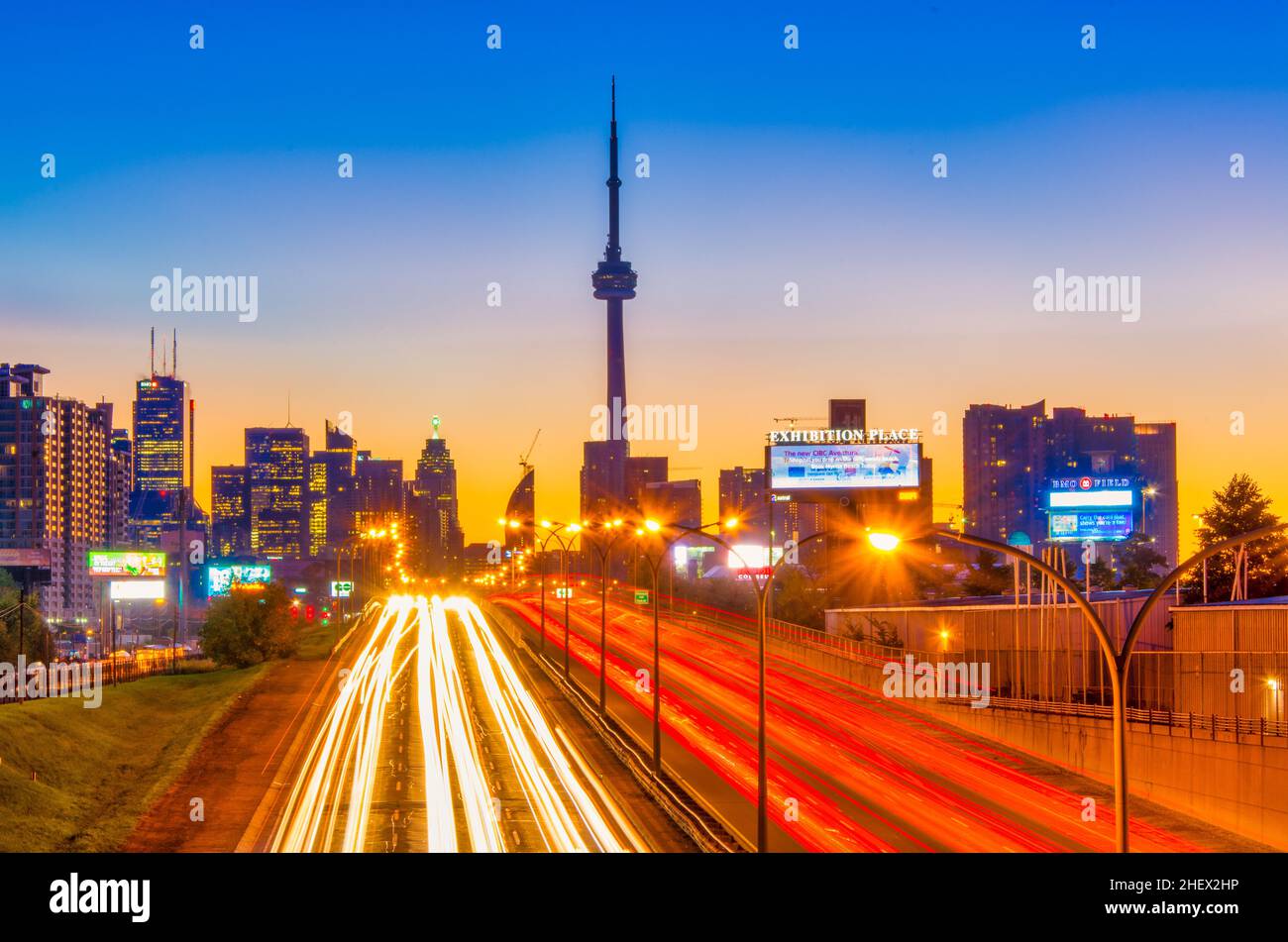 Die Skyline von Toronto und der Gardiner Expressway, der bei Dämmerung in die Innenstadt von Toronto einführt, mit dem CN Tower und anderen Gebäuden im Hintergrund und zwei-Wege-Verkehr in t Stockfoto
