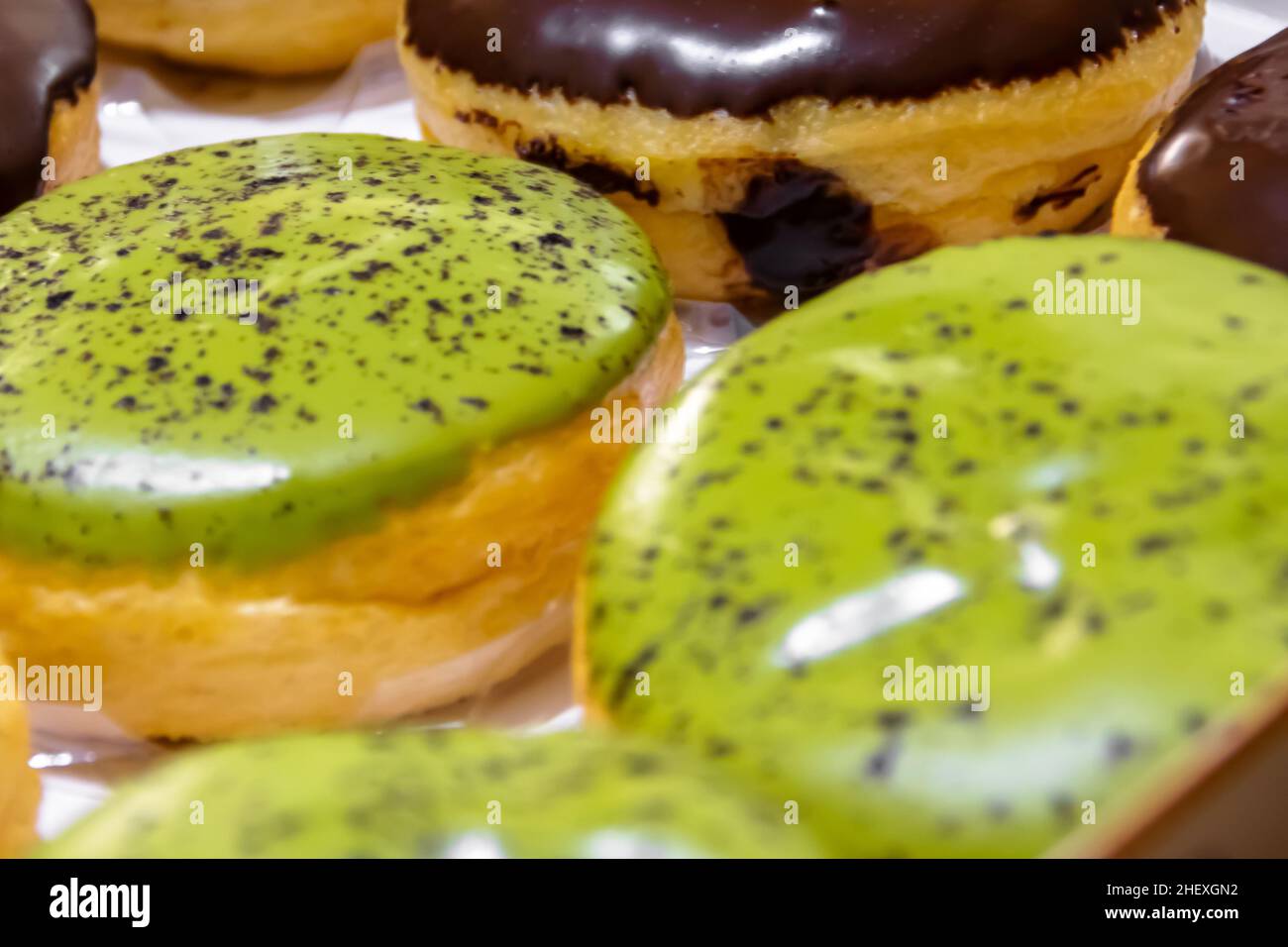 Nahaufnahme von leckeren und leckeren Donuts mit grünem Tee und Schokoladenglasur-Donuts daneben Stockfoto