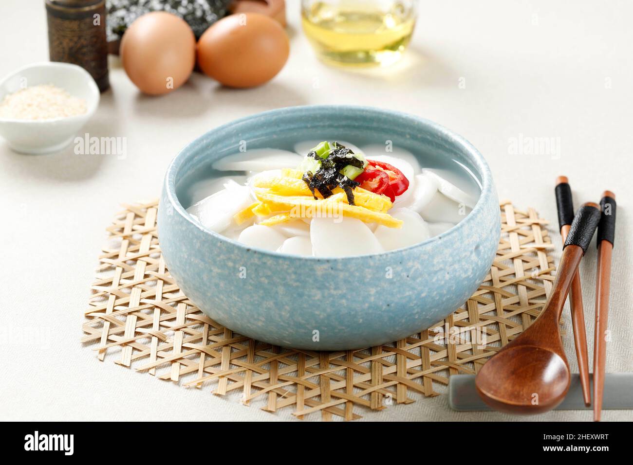 Tteokguk koreanische Reiskonditorei-Suppe für das seelische Neujahr, Topping mit Scheiben Ei, Chili und Sesamsamen Stockfoto