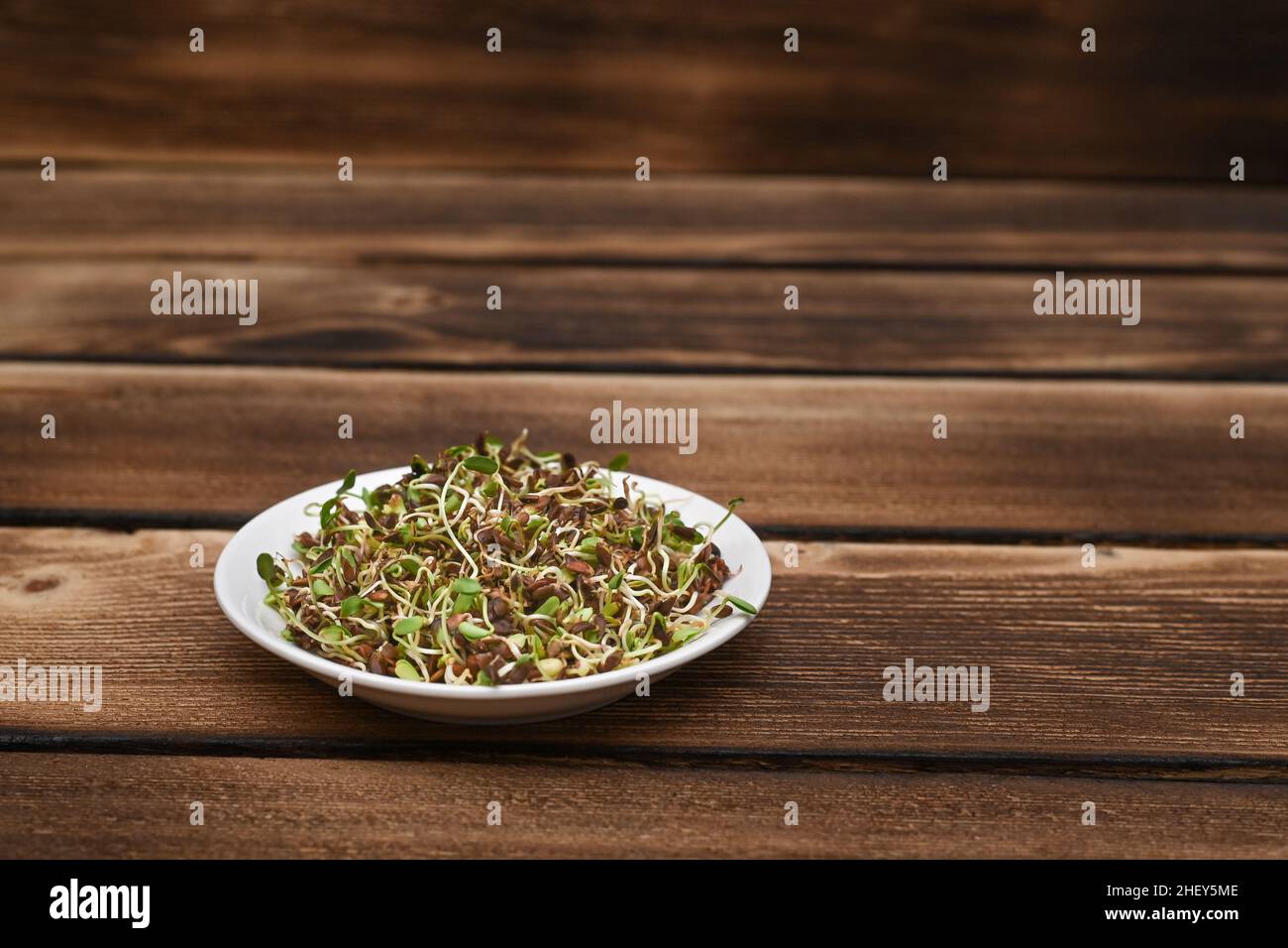 Gekeimt Leinsamen auf einem natürlichen Holzhintergrund auf einem Teller. Gesunde vegetarische Ernährung Stockfoto