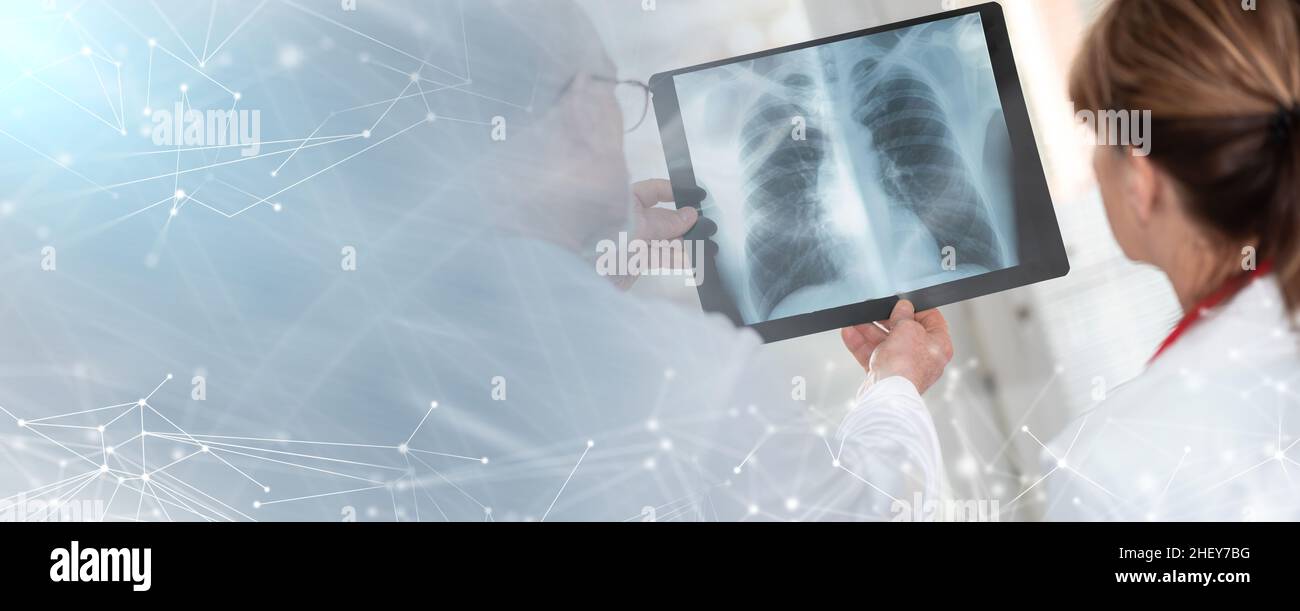 Zwei Ärzte untersuchen Röntgenbericht in der Arztpraxis; Panorama-Banner Stockfoto