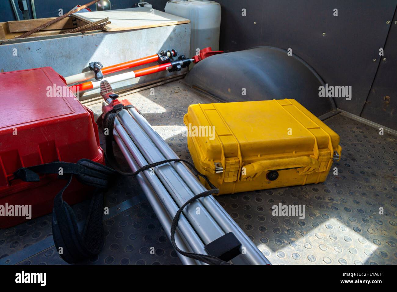 Geodätische Ausrüstung - eine Gesamtstation und ein Stativ mit einem Mast, der in der Kabine eines stillstehenden Autos aufgestellt wurde, noch nicht für den Transport fixiert, selektiv fo Stockfoto