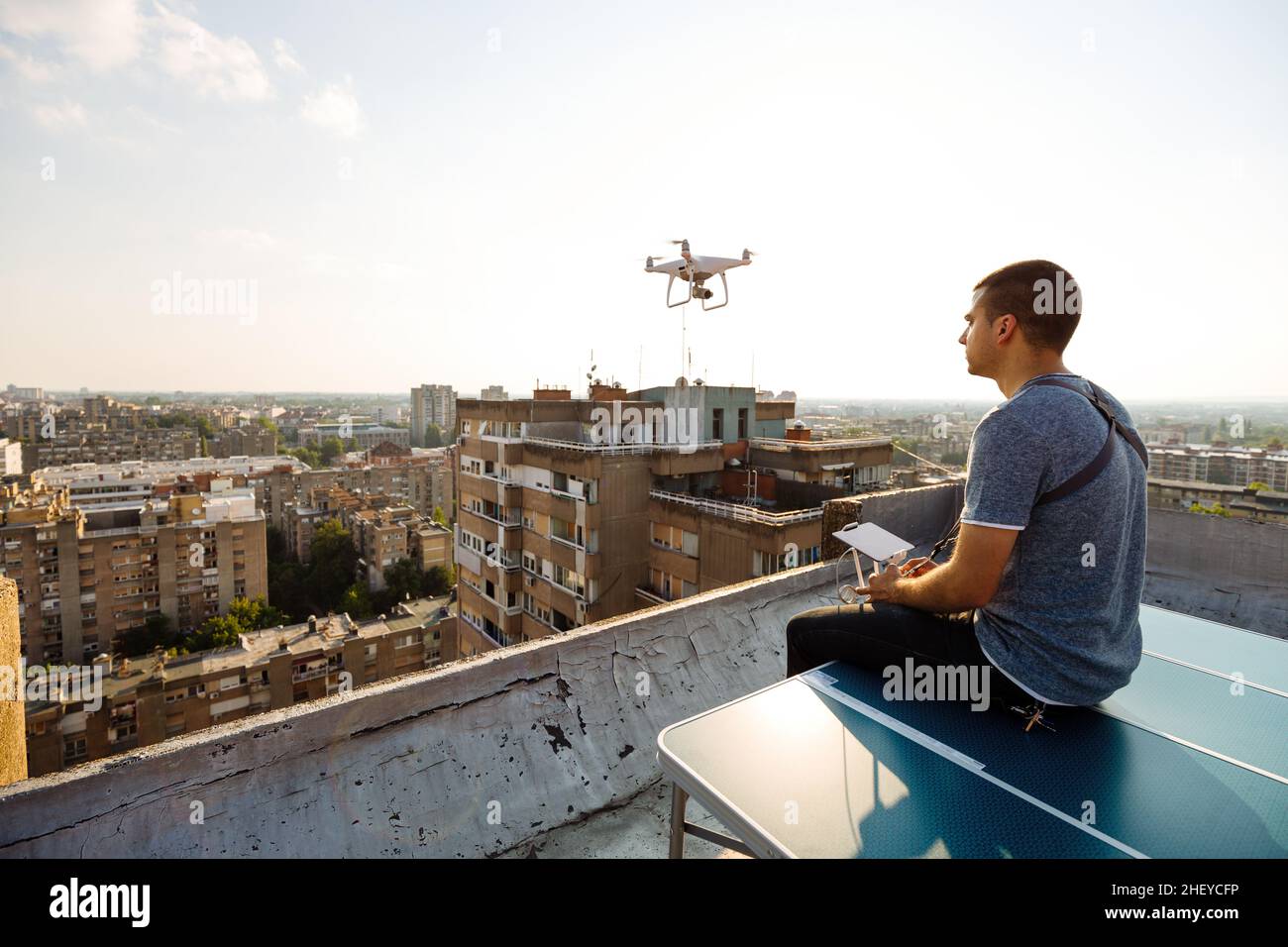 Mann Betrieb einer Drohne mit Fernbedienung auf der Dachterrasse Stockfoto