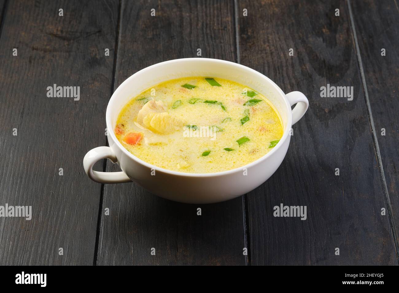 Schüssel mit Seehechtsuppe mit Rahm und Karotten auf einem Tisch Stockfoto