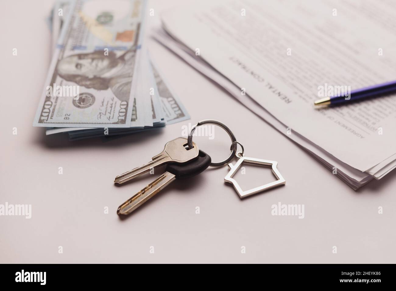 Immobilienkaufvertrag mit Geld und Hausschlüsseln auf weißem Tisch. Mietangebot Geschäftsreise Wohnen langfristige Vermietung. Barzahlung Stockfoto