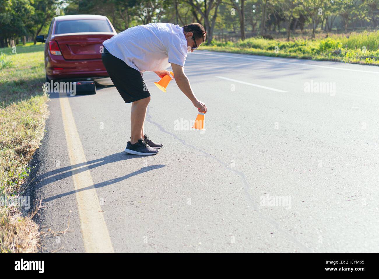 Älterer Mann, der das orangefarbene Schild aufstellte. Stockfoto