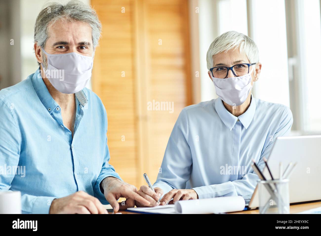Senior Business Epidemien Vertragsunterzeichnung Corona Office Business Agreement Dokumentenmaske Virenschutz Stockfoto