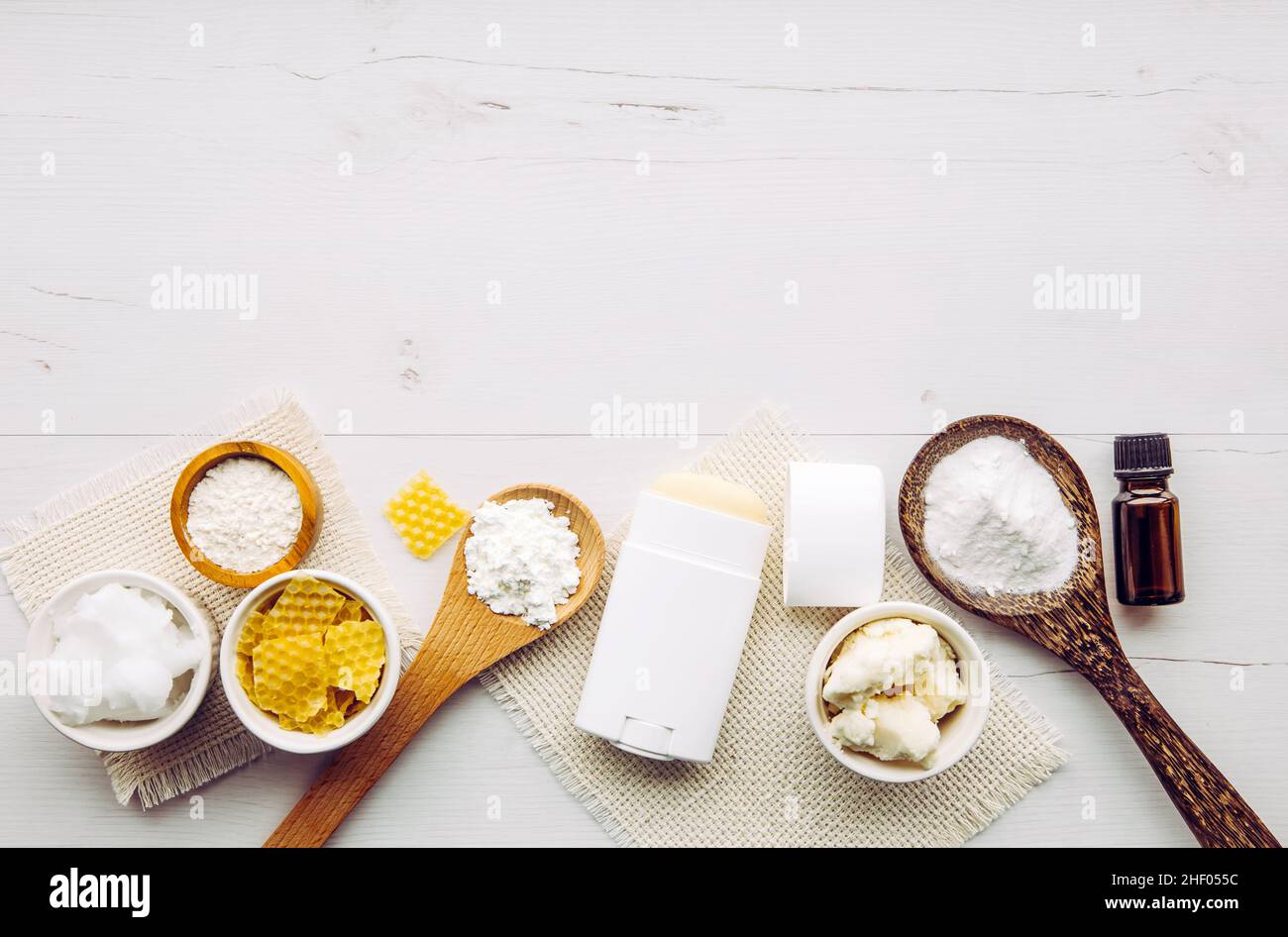 Herstellung hausgemachter Deodorant Stick mit allen natürlichen Zutaten Konzept. Hintergrund aus weißem Holz. Zutaten: Pfeilwurzelpulver, Backpulver, Bienenwachs. Stockfoto