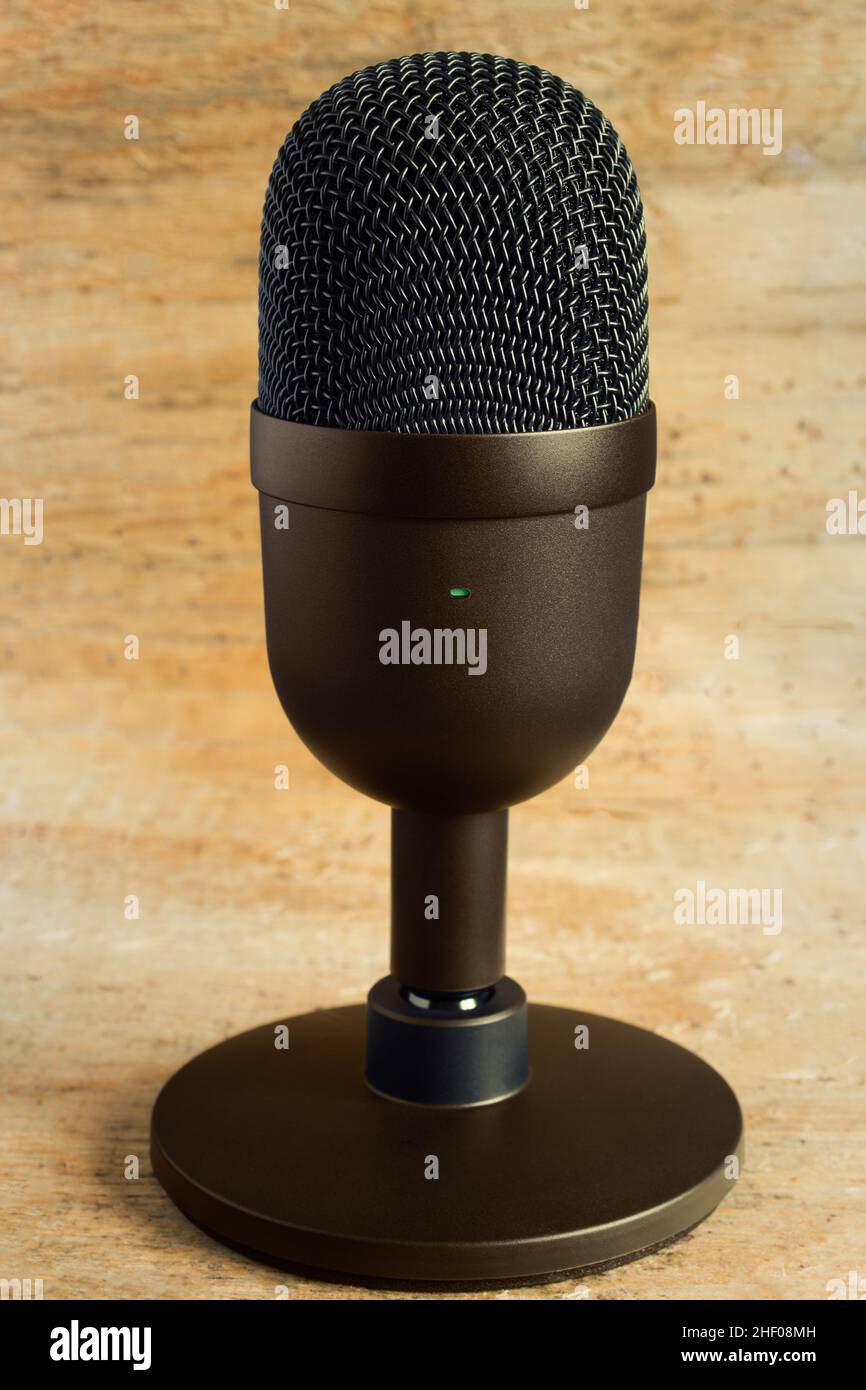 Nahaufnahme eines eleganten Mikrofons in modernem Design für Streaming und Gaming in Metallic-Farbe auf abstrakt glänzendem Hintergrund. Technologie. Stockfoto