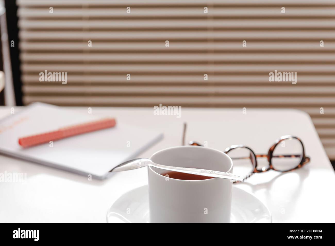 Eine Tasse Tee auf weißem Tisch mit Papeterie Stockfoto