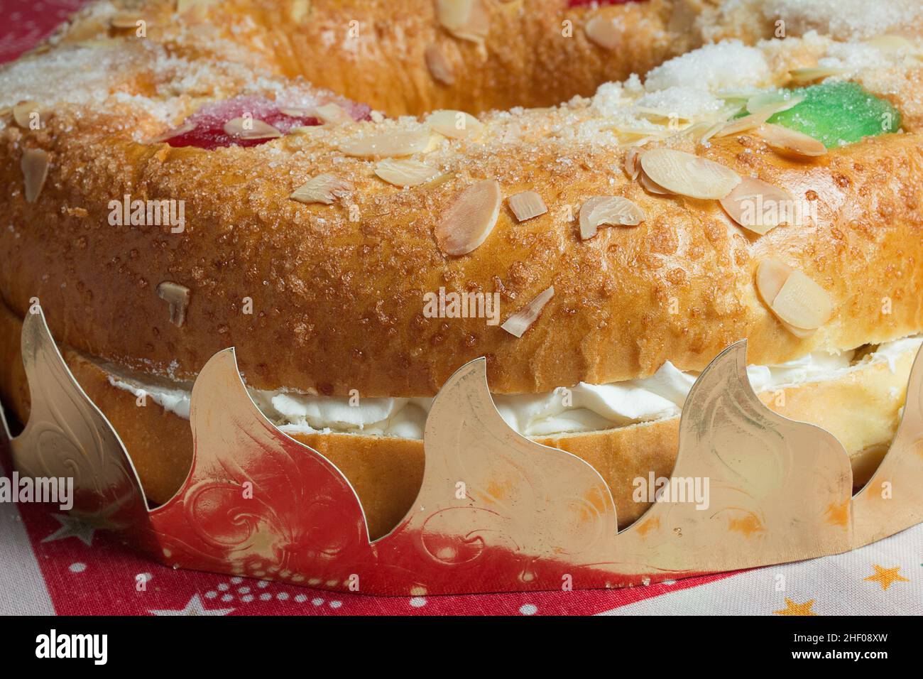 Nahaufnahme eines riesigen Donut-Kuchens, gefüllt mit süßer Schlagsahne und Baiser mit kandierten Früchten, Mandeln und Puderzucker, umgeben von der Traditiona Stockfoto