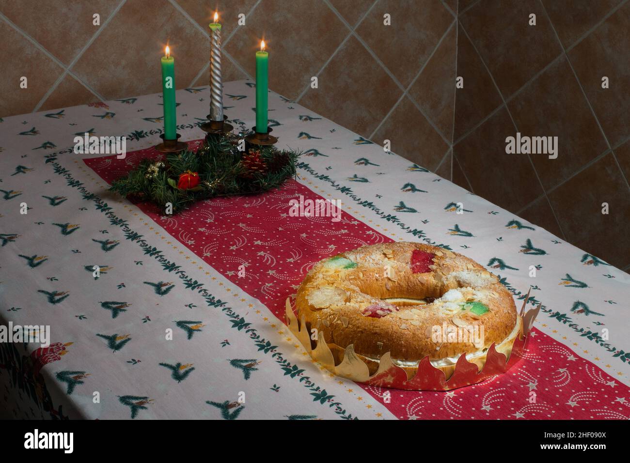 Ein riesiger Donut-Kuchen, gefüllt mit süßer Schlagsahne und Schokoladentrüffel mit kandierten Früchten, Mandeln und Puderzucker auf einer weihnachtlichen Tischdecke mit l Stockfoto