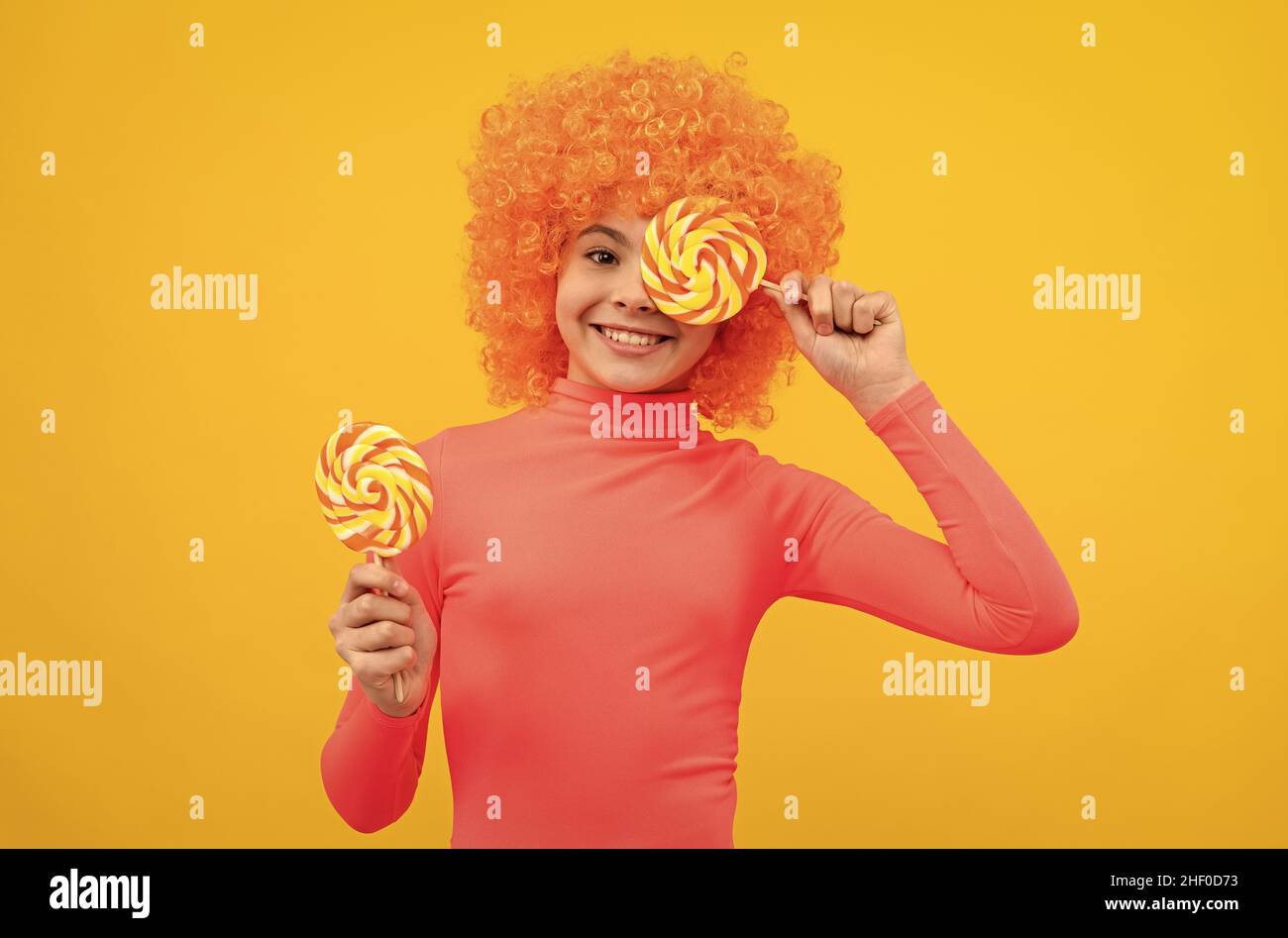 Happy girl Kind mit orangen Haaren in rosa Poloneck haben Spaß halten Lutscher, Mädchenschaft Stockfoto