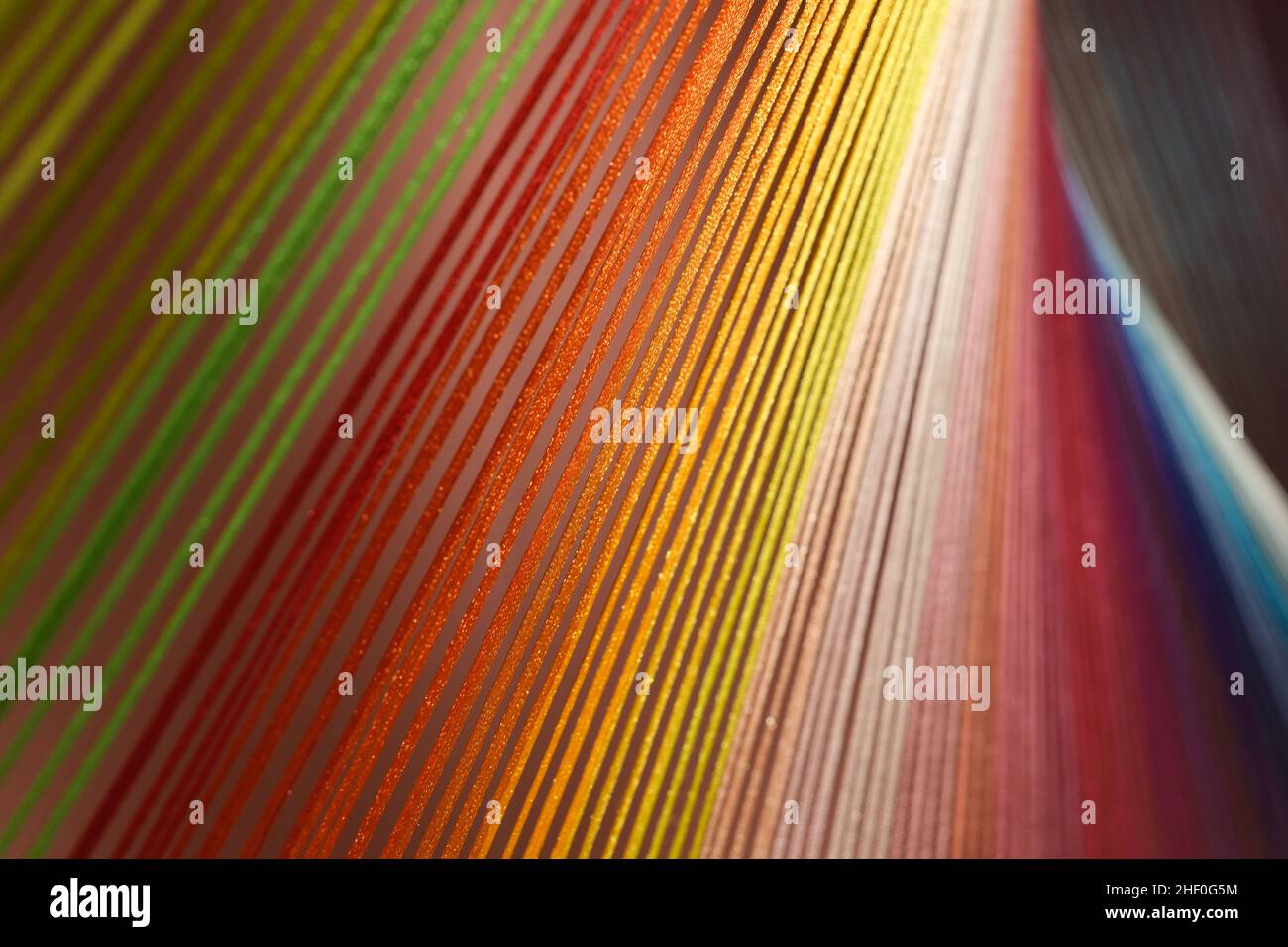 Nahaufnahme von bunten Baumwollfäden unter Licht. Schöner String Hintergrund Stockfoto