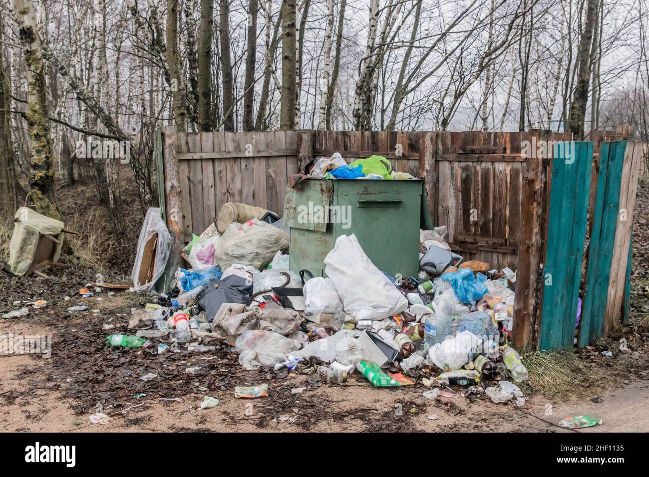 Abfall Glas- und Plastikflaschen und -Beutel am Behälter mit Abfall im Freien. Stockfoto