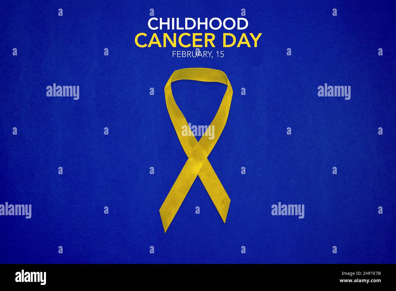 Gelbes Band auf blauem Hintergrund mit Kopierraum. Kinderkrebstag Februar 15 Stockfoto