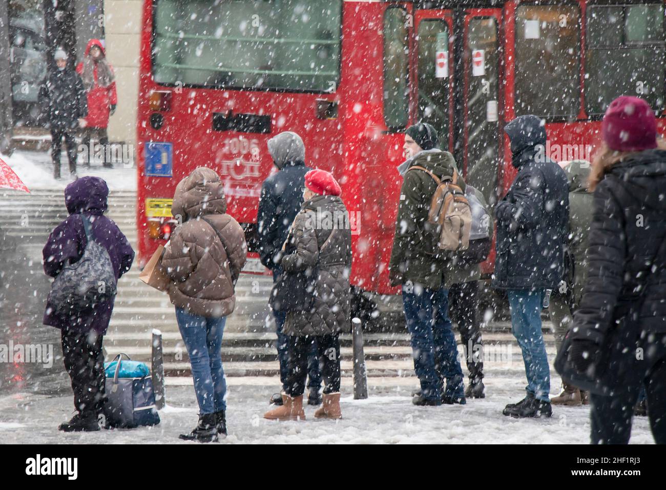 Belgrad, Serbien - 11. Januar 2022: Menschen warten an einer Kreuzung auf einer verschneiten Stadtstraße während eines starken Schneefalls Stockfoto