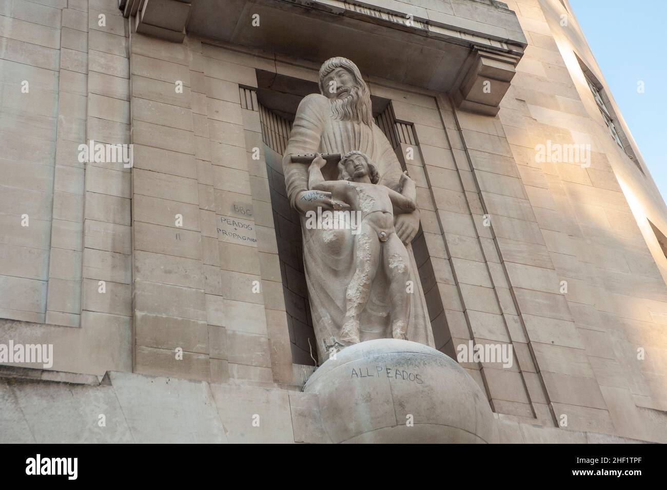 London, Großbritannien. 13th Januar 2022. Mann greift mit Hammer die Statue vor dem BBC Broadcasting House an. Die Schnitzerei zeigt Prospero und Ariel aus Shakespeares der Sturm. Die Kunstwerke von Eric Gill, die 1933 im Londoner Hauptquartier installiert wurden, sind umstritten, weil der Künstler Pädophil war. Die Tagebücher des Bildhauers Eric Gill, die nach seinem Tod im Jahr 1940 veröffentlicht wurden, enthüllten, dass er seine Töchter im Teenageralter sexuell missbraucht hat. Kredit: JOHNNY ARMSTEAD/Alamy Live Nachrichten Stockfoto