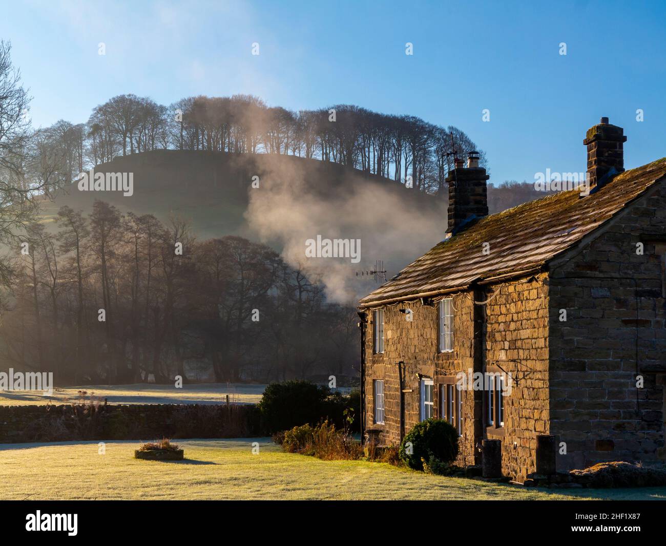 Frostbedeckte Landschaft mit Häusern und Bäumen bei Rowsley im Derbyshire Peak District England, Großbritannien, mit Peak Tor oder Pillow Hill in der Ferne. Stockfoto