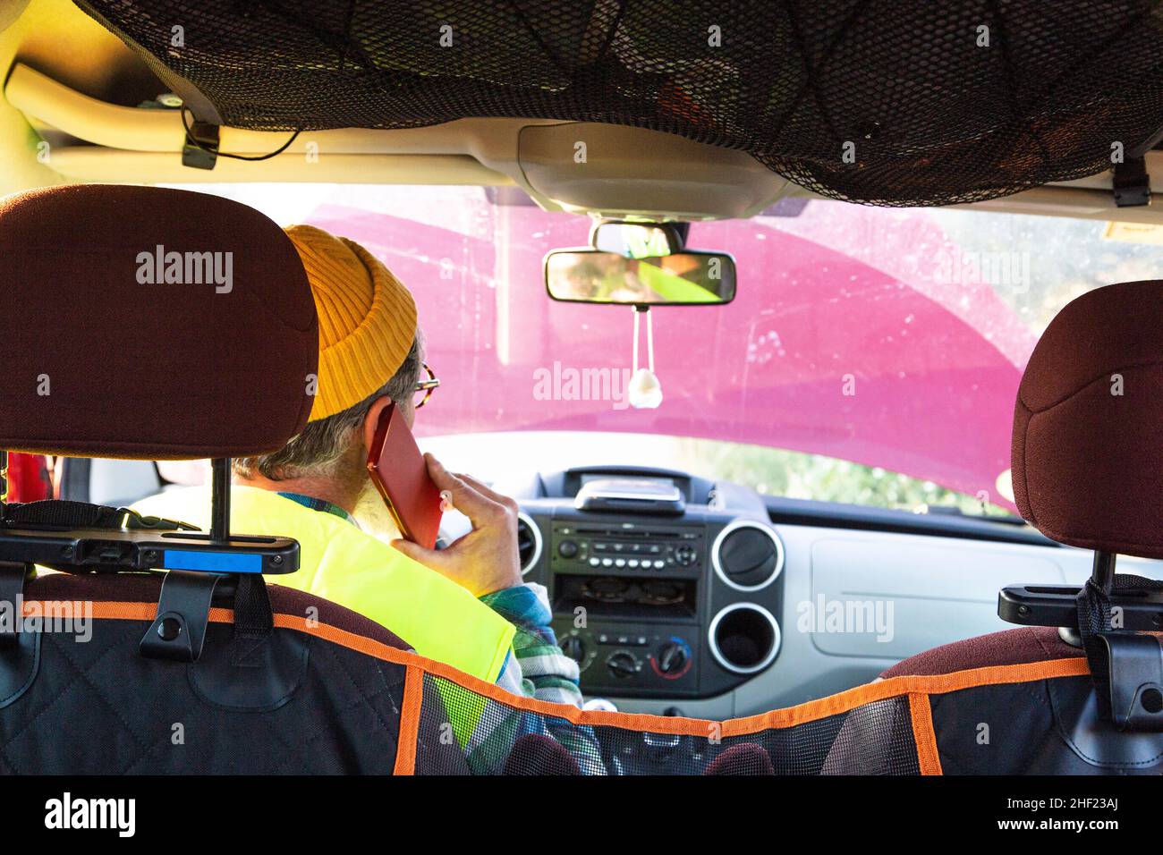 Mann in der Kabine des beschädigten Fahrzeugs telefoniert mit Pannenhilfe Stockfoto
