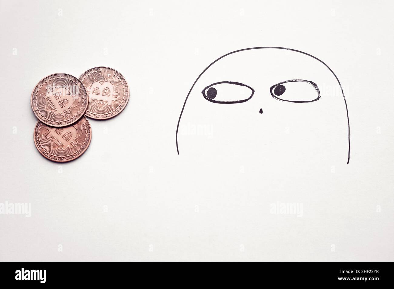 Bitcoins auf Papier mit einem verdächtigen Doodle-Gesicht, Konzept der Überwachung der Bitcoin-Preise Stockfoto