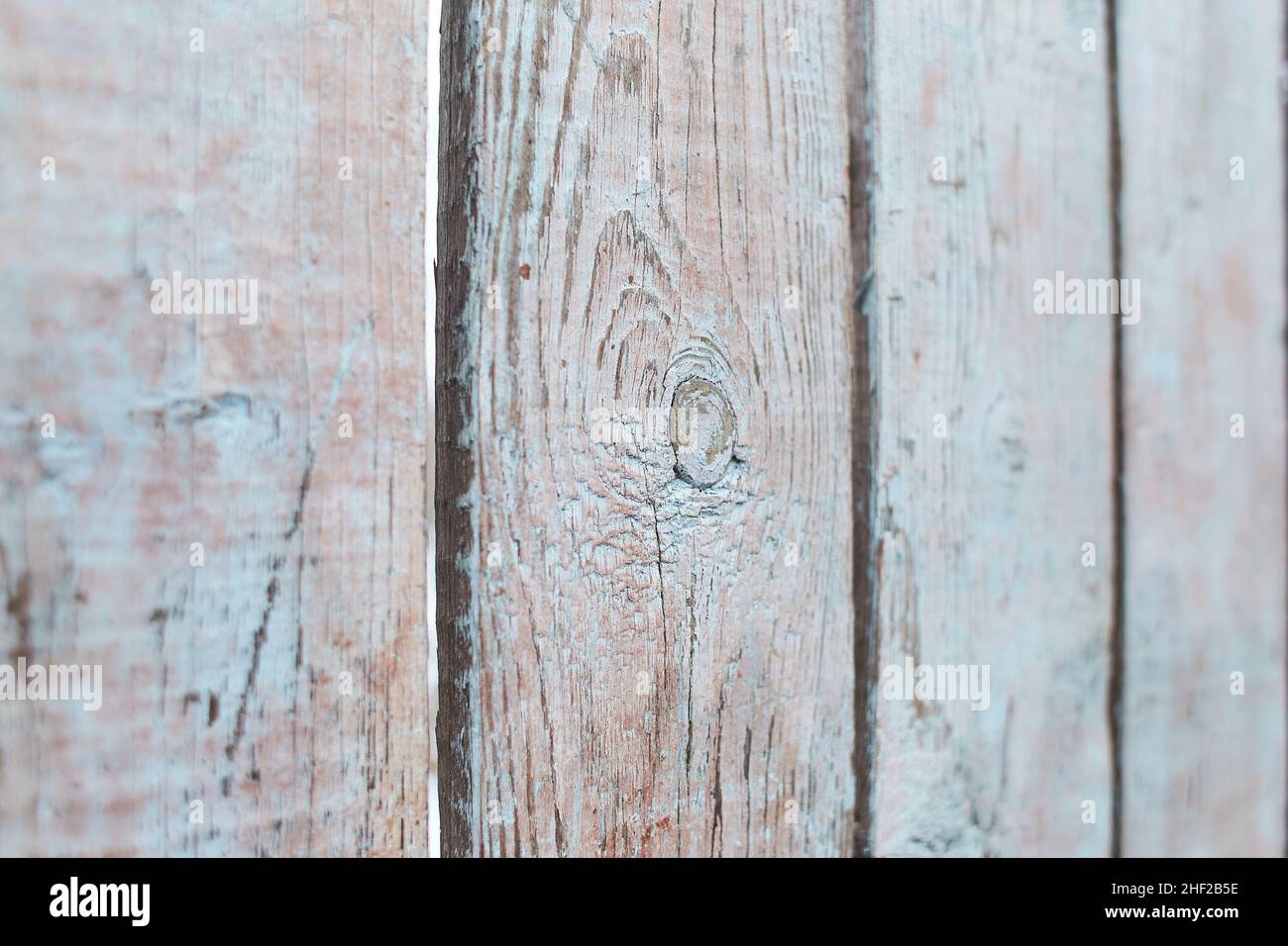 Alte schäbige Holzplanken mit rissiger Farbe, Hintergrund. Hellblau Stockfoto