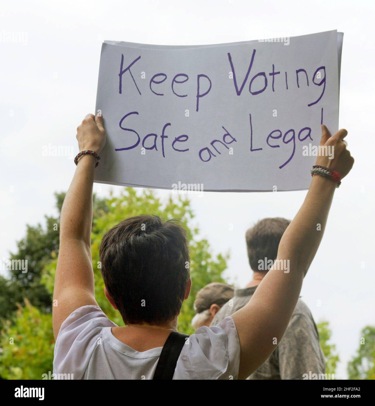 Die junge Demonstratorin trägt ein Zeichen, das sagt: „Halten Sie die Abstimmung sicher und legal“, ein Zeichen der Zeit. Stockfoto