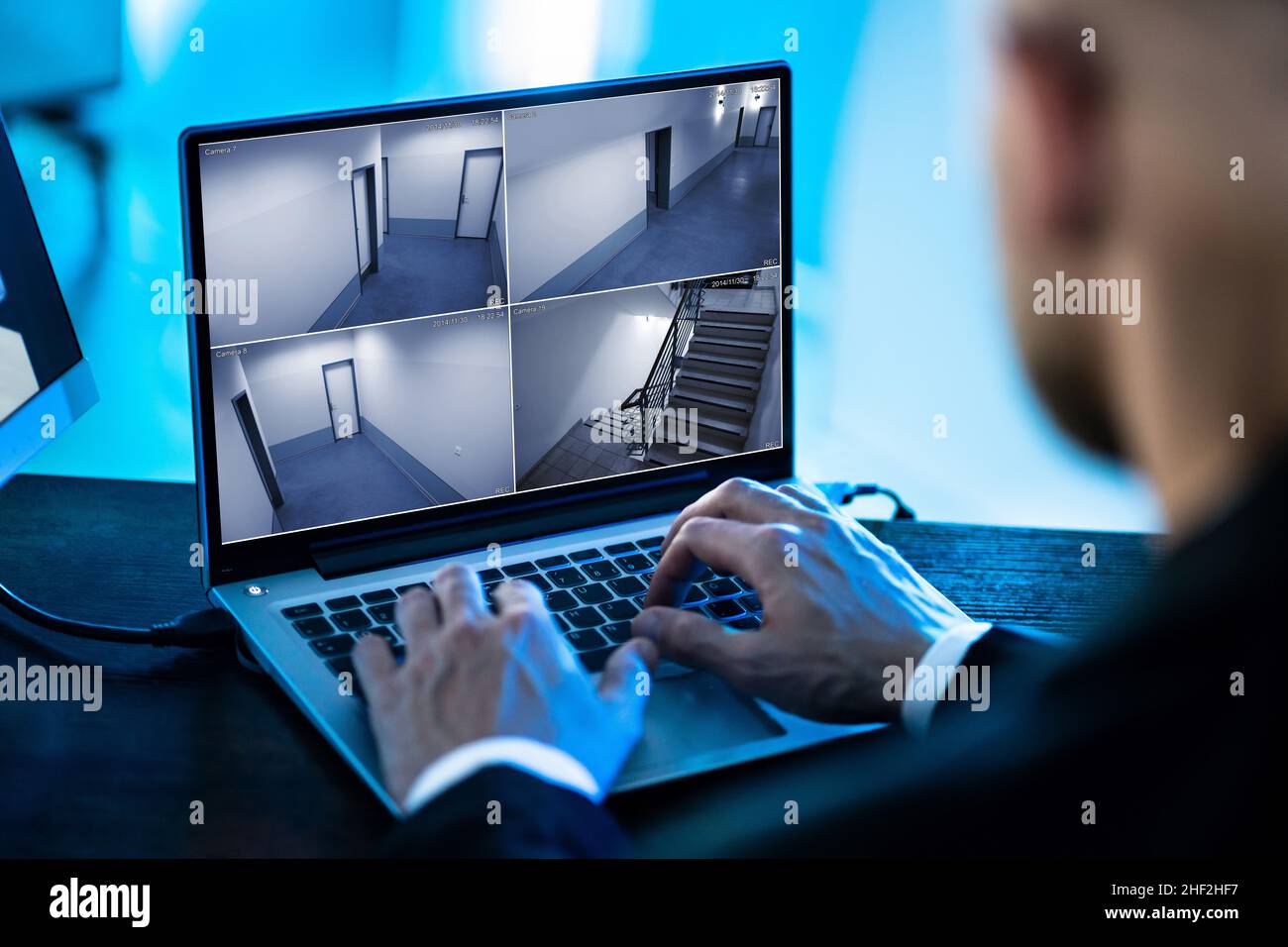 Der Bediener des Sicherheitssystems sieht sich CCTV-Aufnahmen am Schreibtisch an Büro Stockfoto