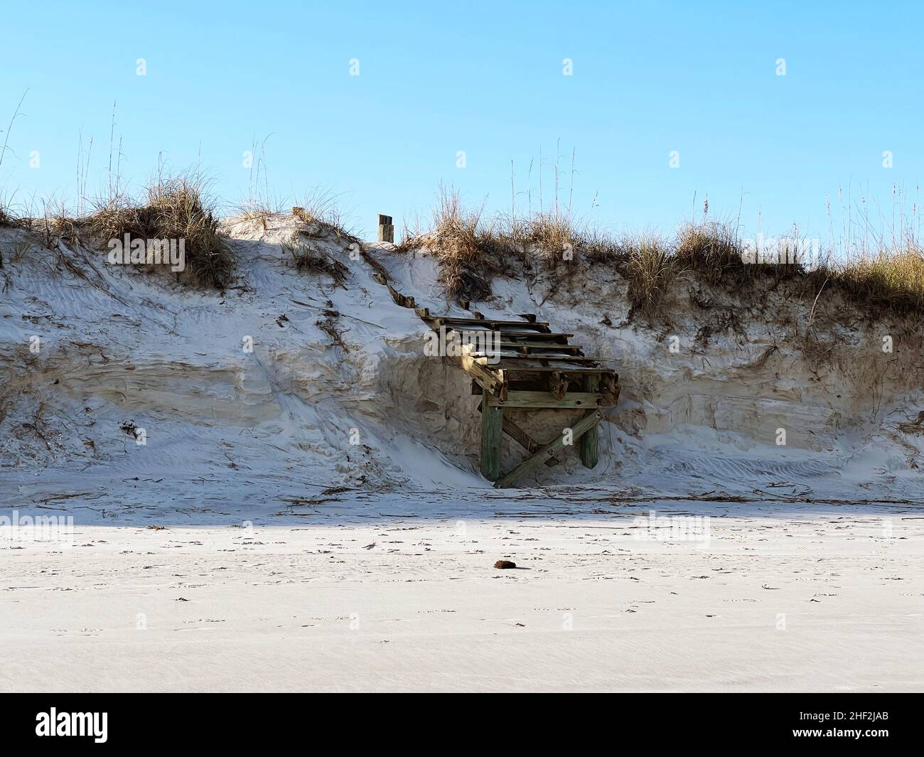 Die durch anhaltende Erosion aufgrund von Stürmen und steigenden Meeresspiegels beschädigten Stufen zum Strandzugang wurden am südlichen Ende der Insel Jekyll, Georgia, USA, gewaschen. Stockfoto