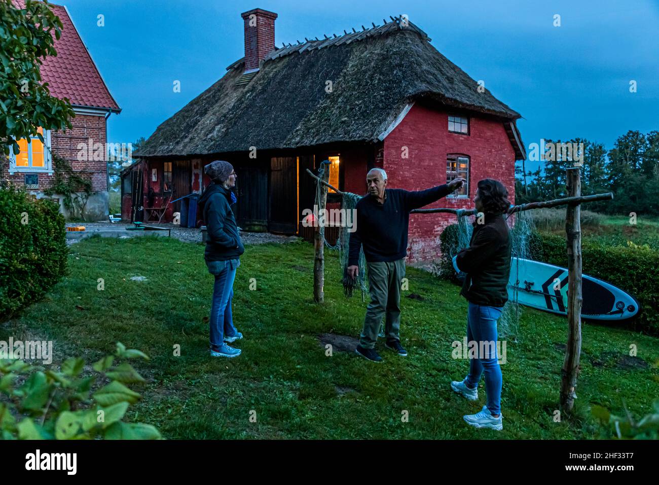 Reisejournalistin Angela Berg im Abendgespräch mit Cecilia Blixen und ihrem Vater Christian im Garten der Villa Skovly, Hesselager, Dänemark Stockfoto