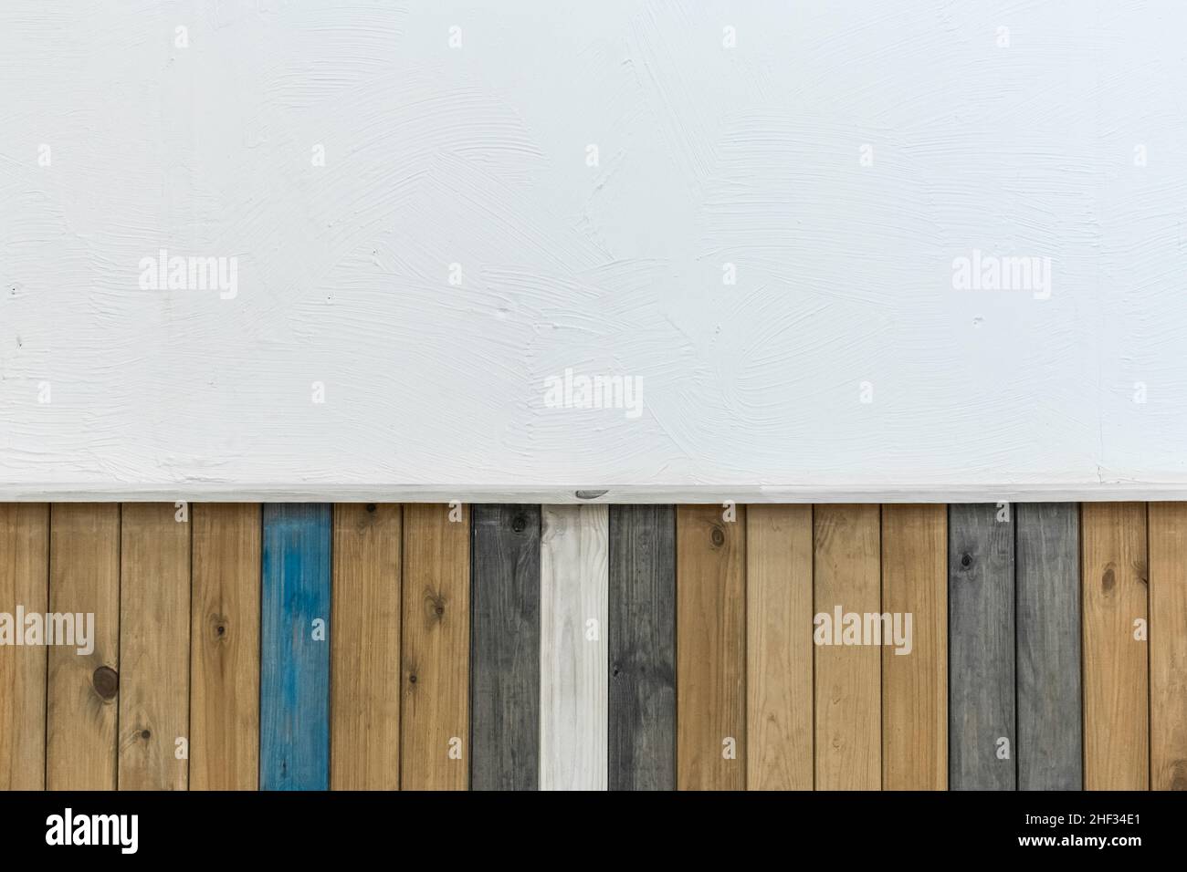 Farbige Holzbretter im Innenraum des Zimmers mit einem weißen leeren, sauberen Wanddeko-Design-Hintergrund. Stockfoto
