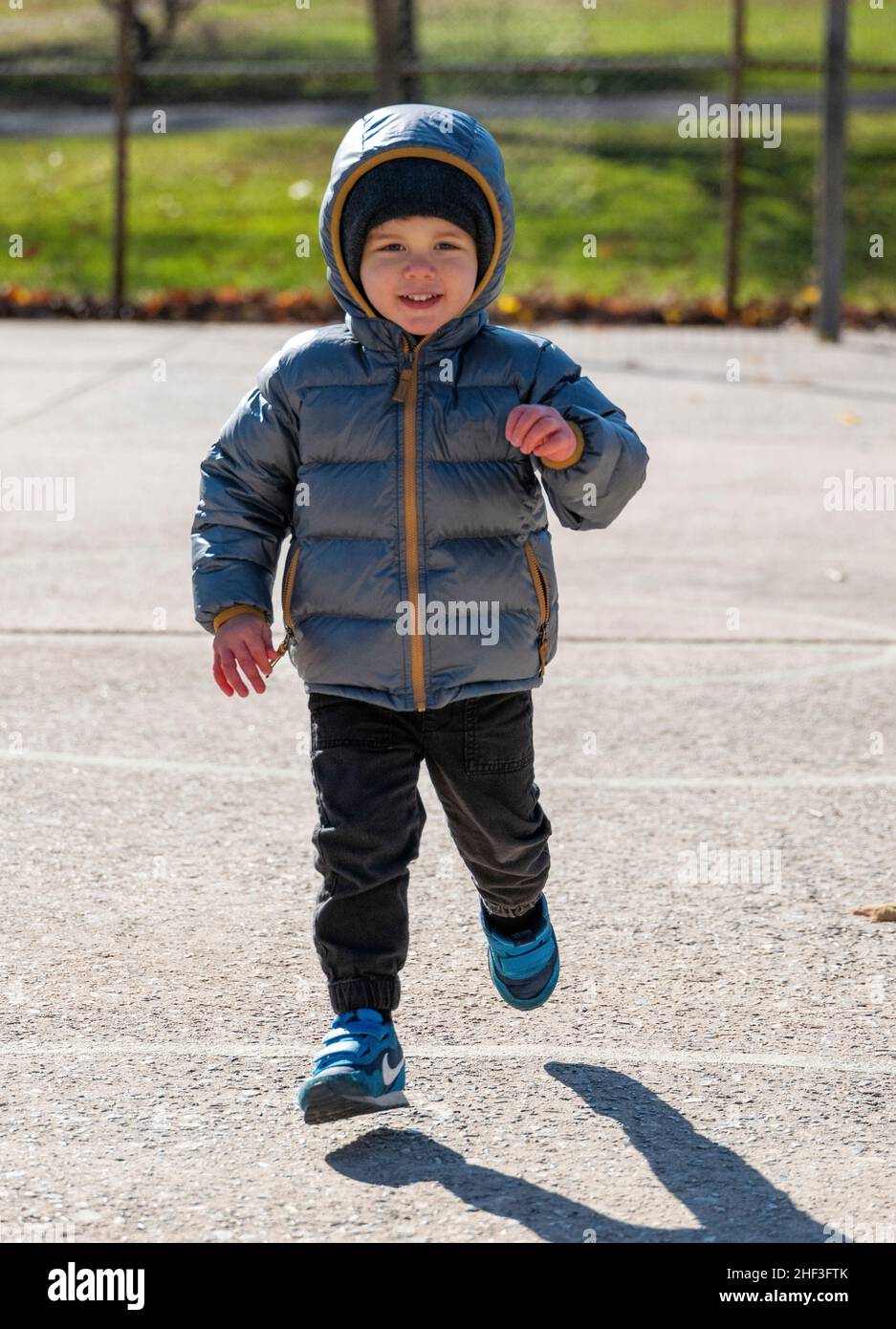 Zweijähriger Junge, der auf dem Spielplatz im Stadtpark läuft; Corinthian Gardens; Philadelphia; Pennsylvania; USA Stockfoto