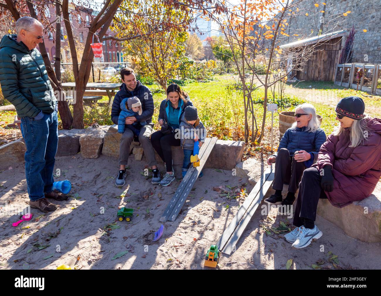 Familie lachend und genießen Kinder spielen in Park Sandbox Stockfoto