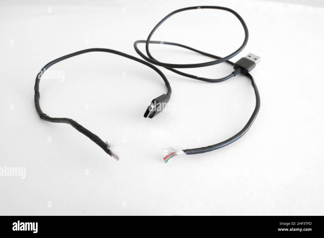 USB-Ladekabel des Telefons vom Typ C ausgefranst, defekt, gerissen und getrennt, was zu einer Fehlkommunikation oder mangelnder Kommunikation zwischen zwei Parteien führt. Stockfoto