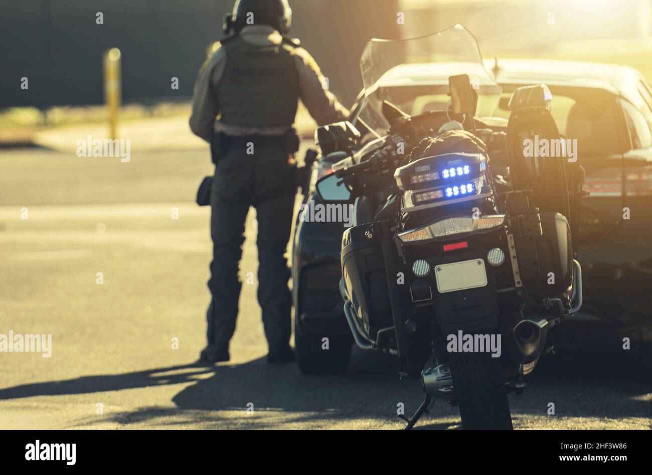 Motorrad-Polizeibeamter gibt Verkehrsticket an den Geschwindigkeitsfahrer. Fahrstil. Stockfoto