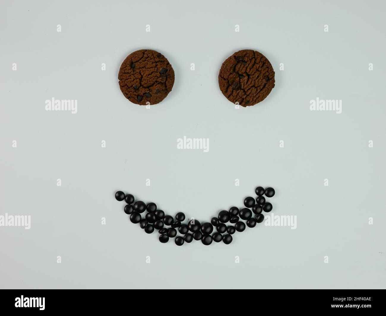 Kreatives Foto von Chocolate Chip Cookies, die ein lächelndes Gesicht bilden. Stockfoto