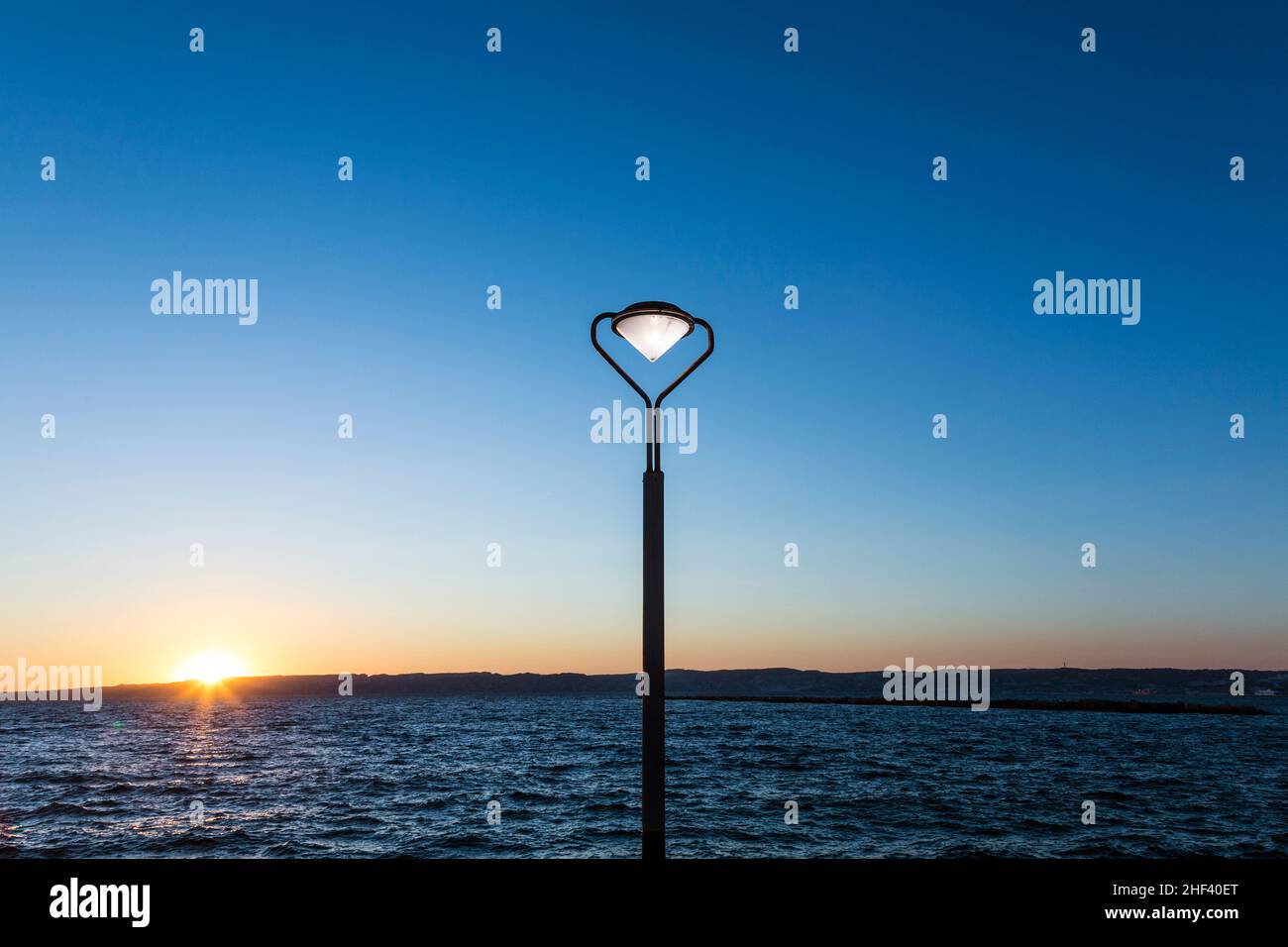 Laterne mit brennenden Licht bei Sonnenuntergang an der Corniche, Marseille Stockfoto